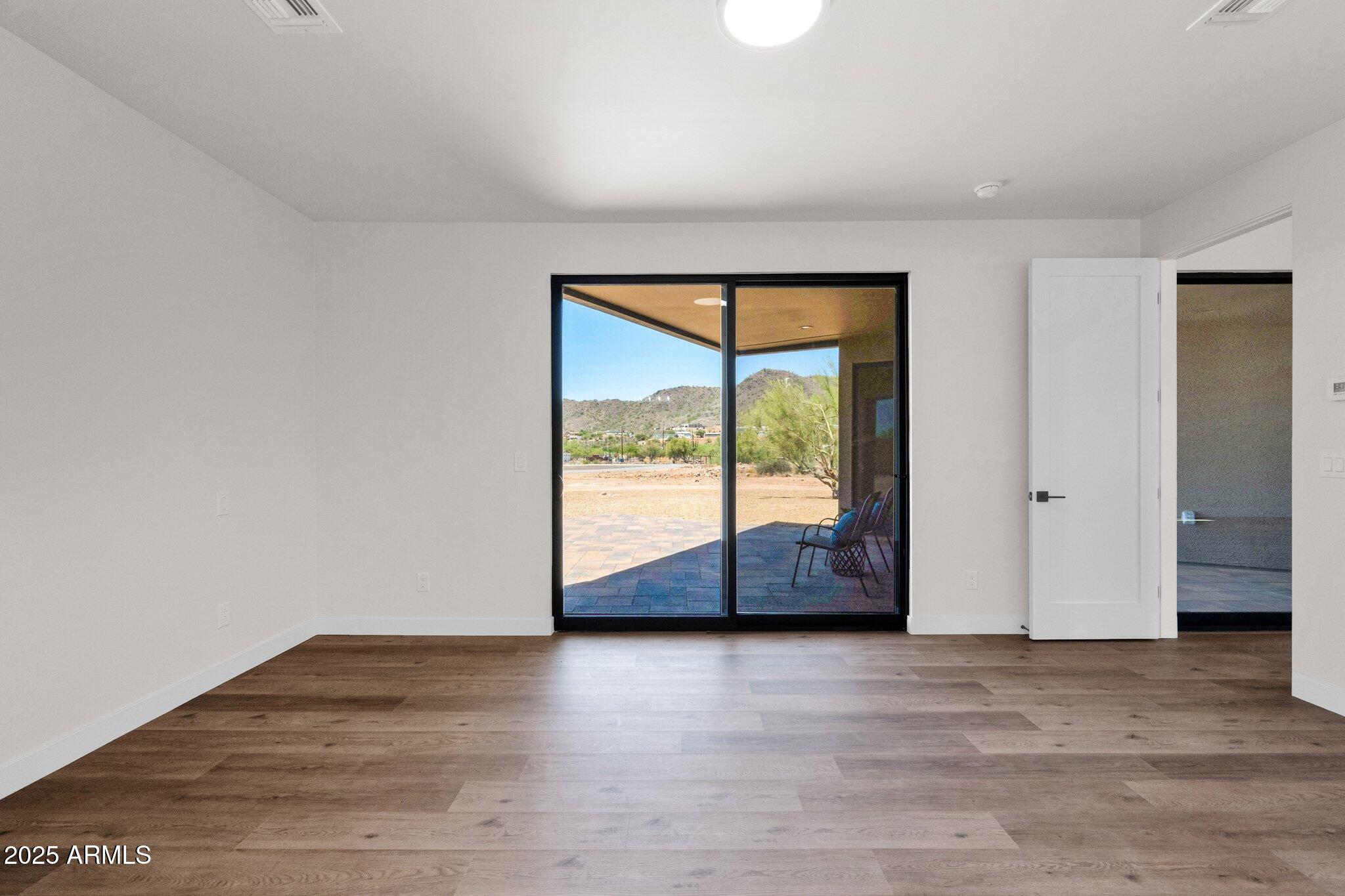 553 West Cavalry Road New River, AZ 85087 - Photo 13 of 26 a view of an empty room with wooden floor and a window