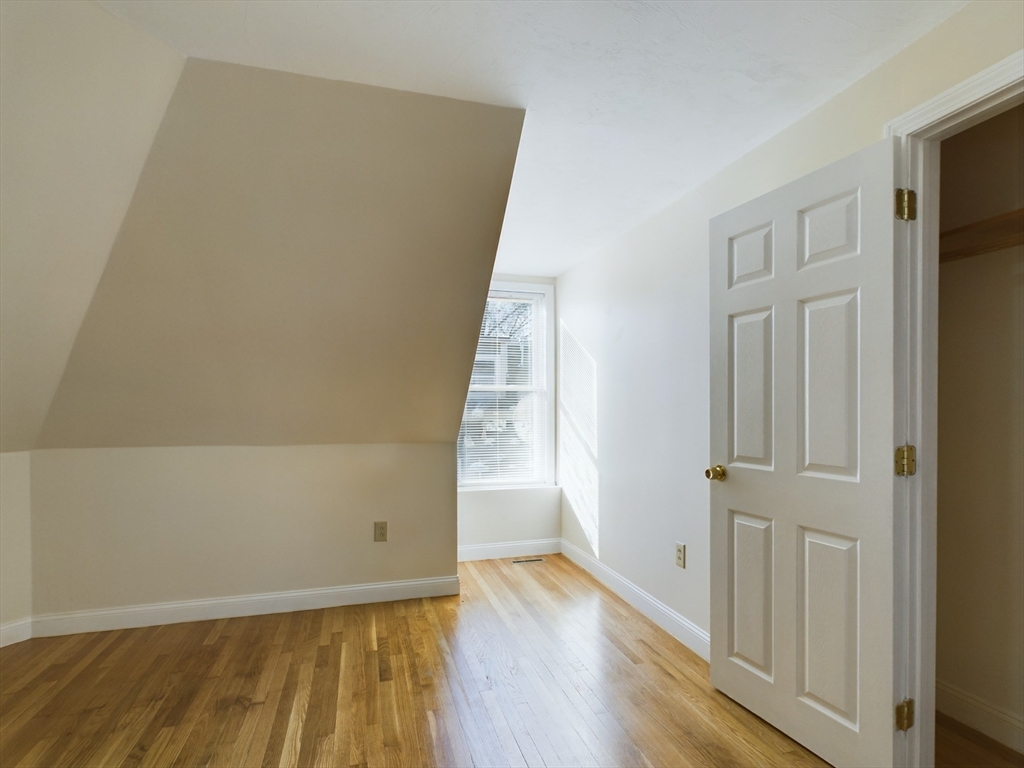 15 Norfolk Street, Unit 2 Boston, MA 02124 - Photo 11 of 14 an empty room with wooden floor and windows
