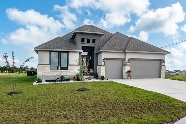 a front view of a house with a yard and trees