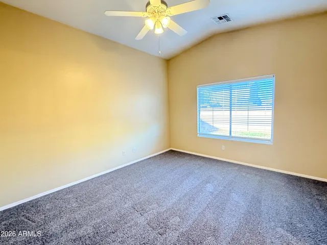 an empty room with a ceiling fan and a window