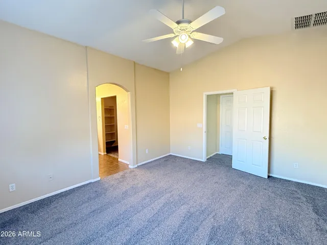 an empty room with a ceiling fan and a window