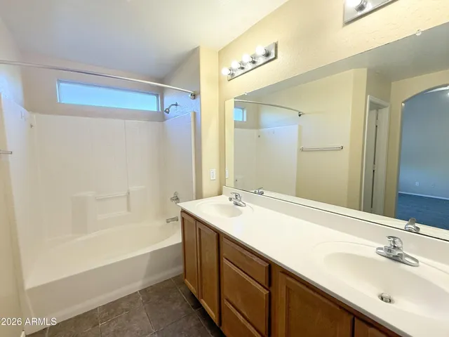 a spacious bathroom with a bathtub sink mirror vanity and toilet