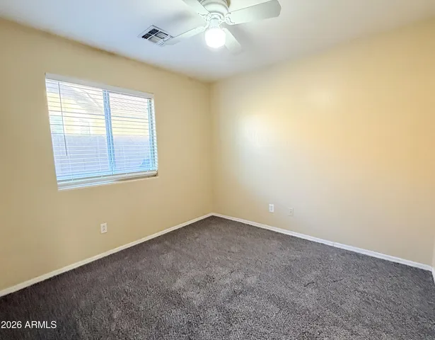 a view of an empty room and chandelier fan