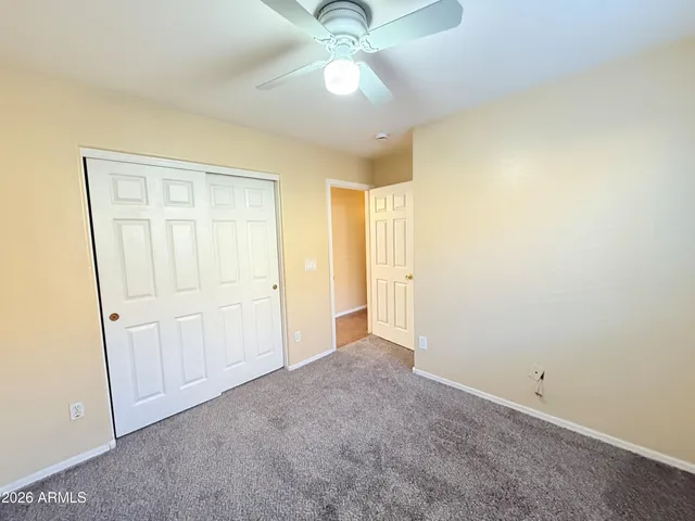an empty room with a window and a ceiling fan