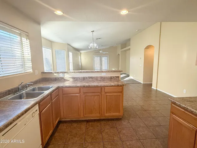 a large kitchen with granite countertop a sink and cabinets
