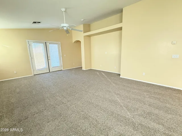 a view of a big room with windows and chandelier fan