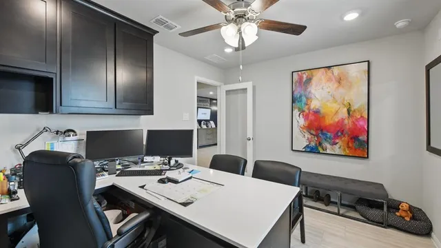 a view of a workspace with furniture and a window