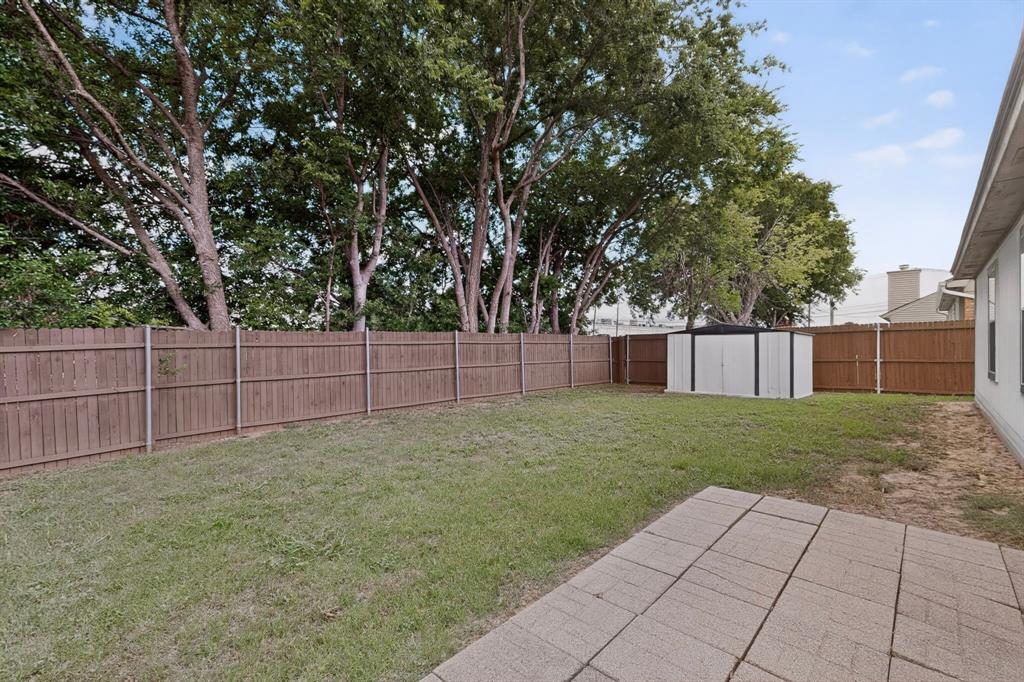 7729 Misty Ridge Drive North Fort Worth, TX 76137 - Photo 28 of 30 a view of a backyard with a large tree and wooden fence