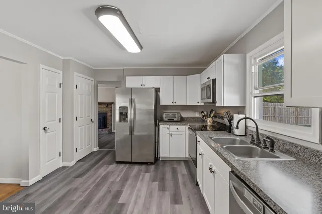 a kitchen with a refrigerator sink and cabinets
