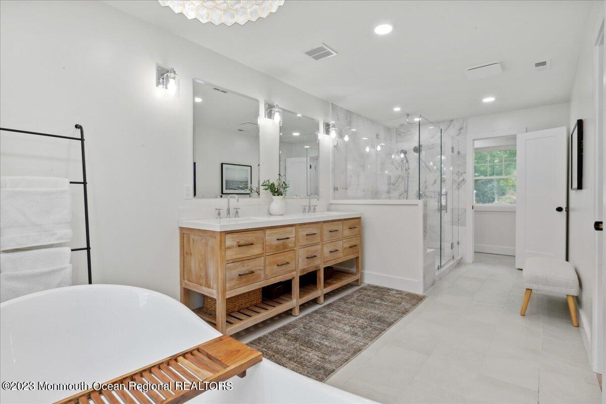 17 Quaker Road Middletown, NJ 07748 - Photo 34 of 65 a bathroom with a double vanity sink a mirror and a shower