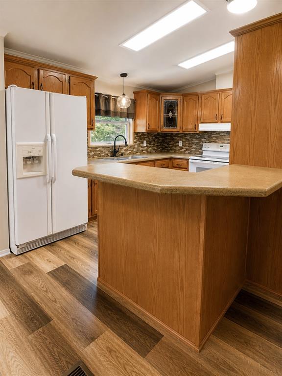9455 Tranquil Acres Road Fort Worth, TX 76179 - Photo 9 of 20 Kitchen featuring wood-finish cabinetry, a textured tile backsplash, and a breakfast bar