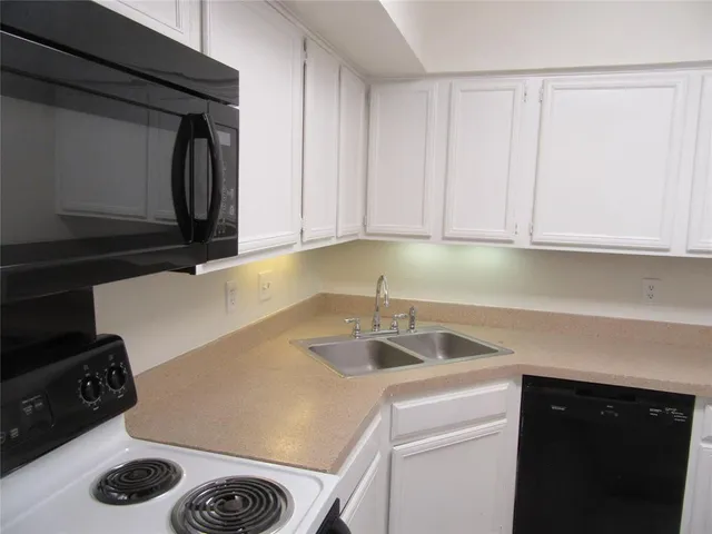 a kitchen with a sink a stove and cabinets