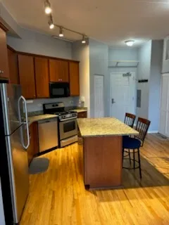 a kitchen with stainless steel appliances granite countertop a sink a stove counter space and cabinets