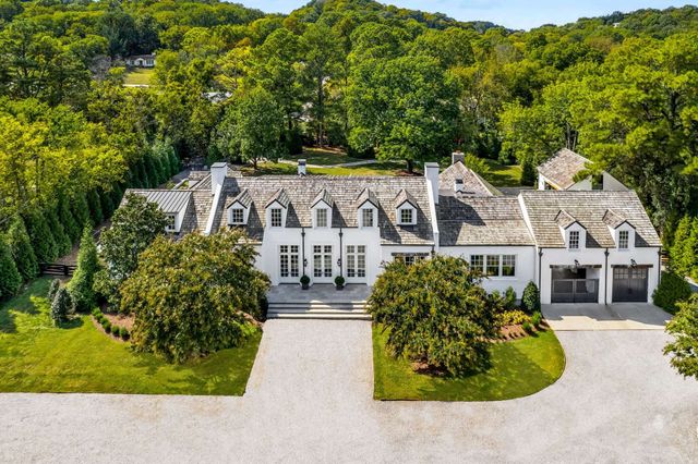a view of a white house with a yard and potted plants