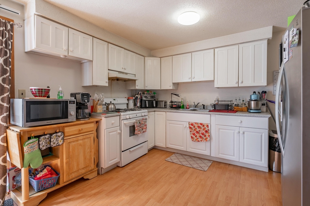 11 Shawnee Road Pepperell, MA 01463 - Photo 5 of 22 a kitchen with stainless steel appliances granite countertop a refrigerator sink and white cabinets