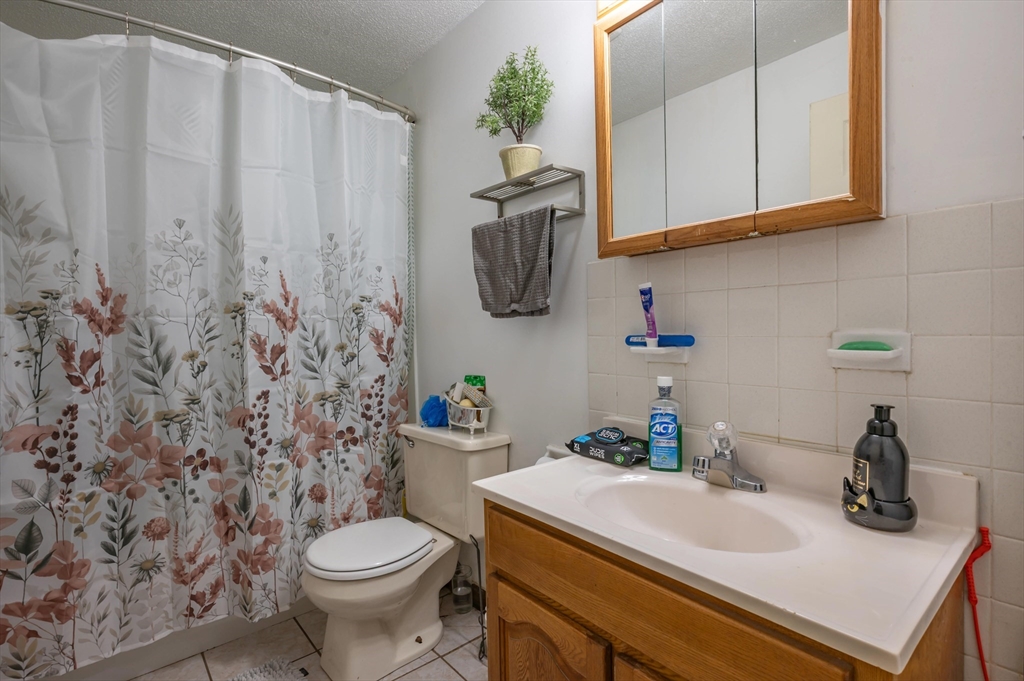 11 Shawnee Road Pepperell, MA 01463 - Photo 10 of 22 a bathroom with a sink a toilet and shower curtain