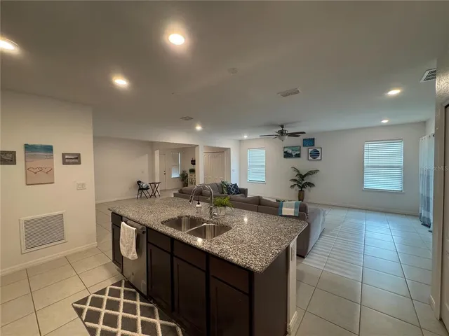 a kitchen with a sink a counter space and chairs
