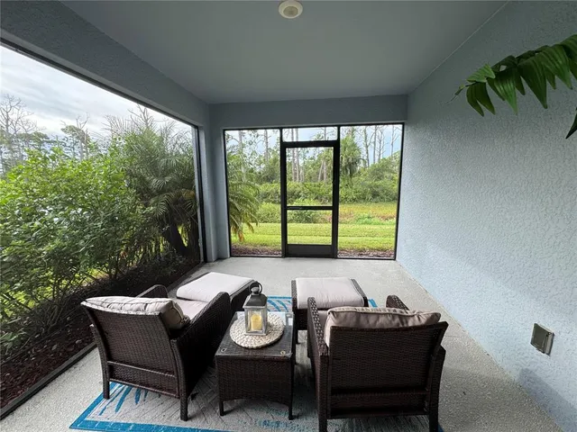 a dining room with furniture and a floor to ceiling window