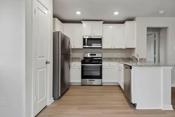 a kitchen with stainless steel appliances granite countertop a refrigerator and a stove top oven