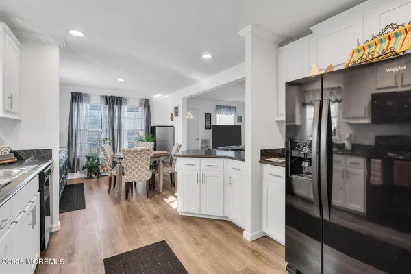 a kitchen with a dining table wooden floor and a view of living room