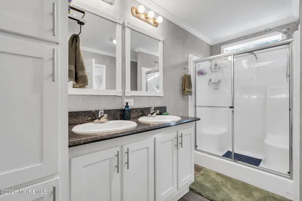 a bathroom with a double vanity sink mirror and shower