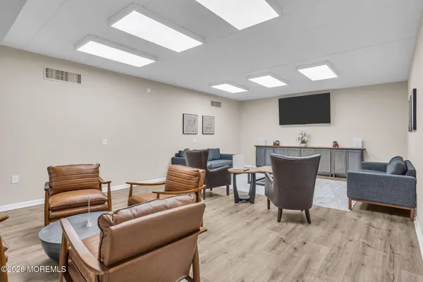 a living room with furniture a flat screen tv and kitchen view