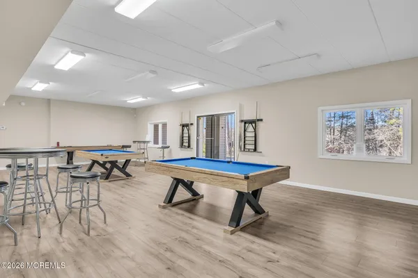 a room with furniture pool table and wooden floor