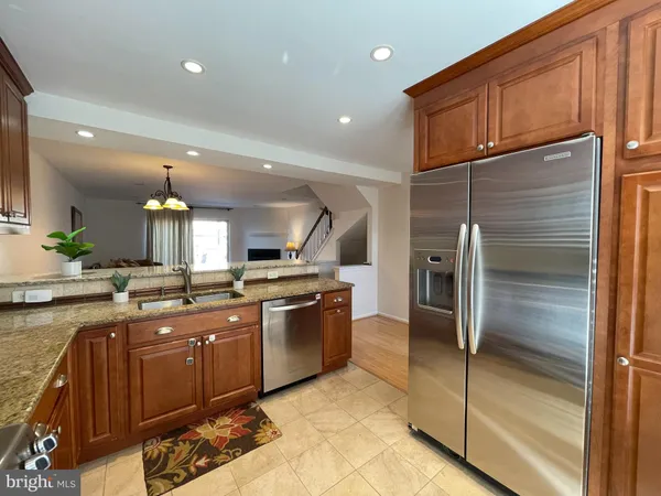 a kitchen with stainless steel appliances granite countertop a sink and a refrigerator