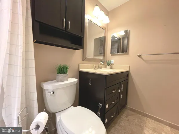 a bathroom with a sink vanity mirror and toilet