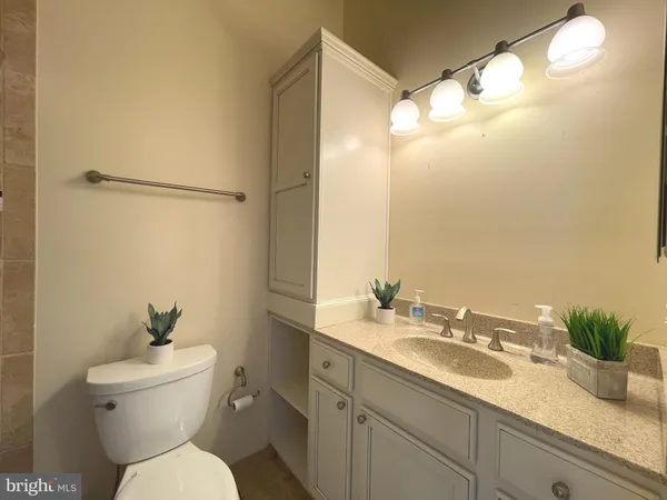 a bathroom with a granite countertop sink toilet and shower