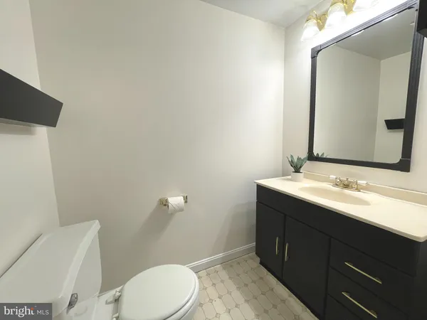 a bathroom with a granite countertop sink mirror and toilet