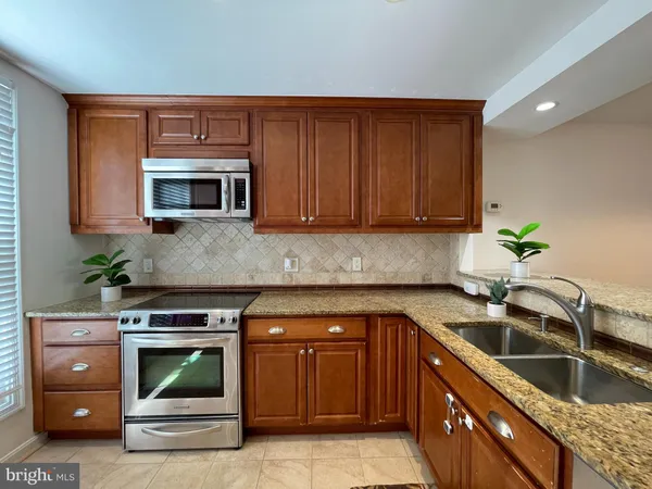 a kitchen with granite countertop a sink and a stove top oven