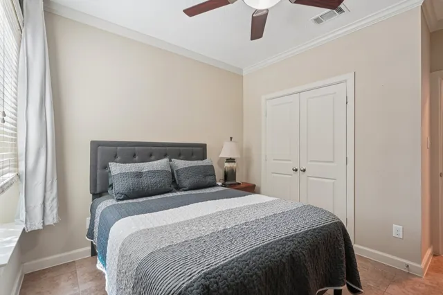 a bedroom with a large bed and a chandelier