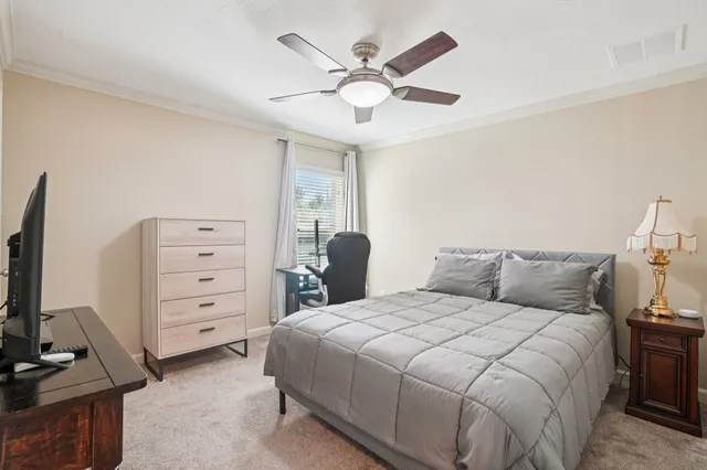 a bedroom with a bed and a flat tv screen on dresser