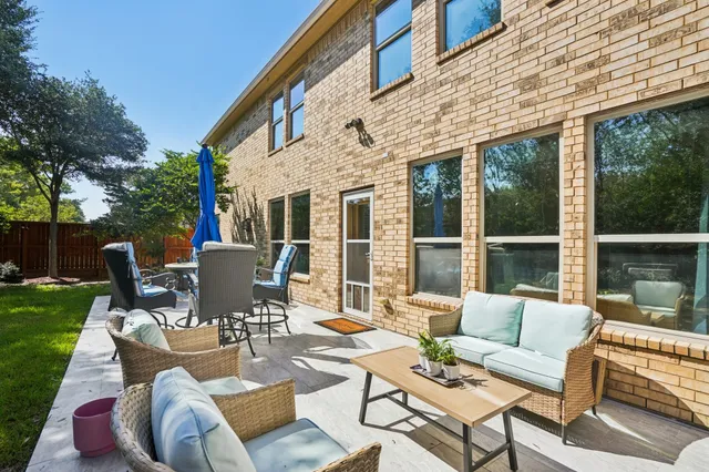 a view of a patio with couches table and chairs and potted plants