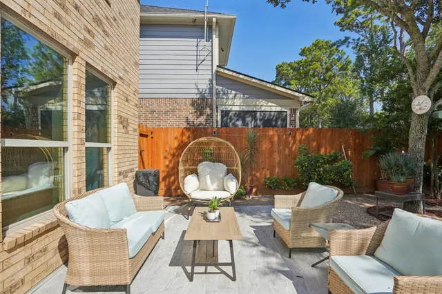 a view of a patio with couches table and chairs and potted plants