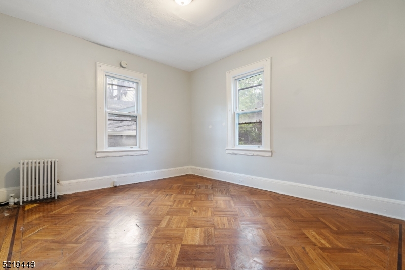 148 Lyons Avenue, Unit 1 Newark, NJ 07112 - Photo 5 of 9 a view of an empty room with a window and wooden floor