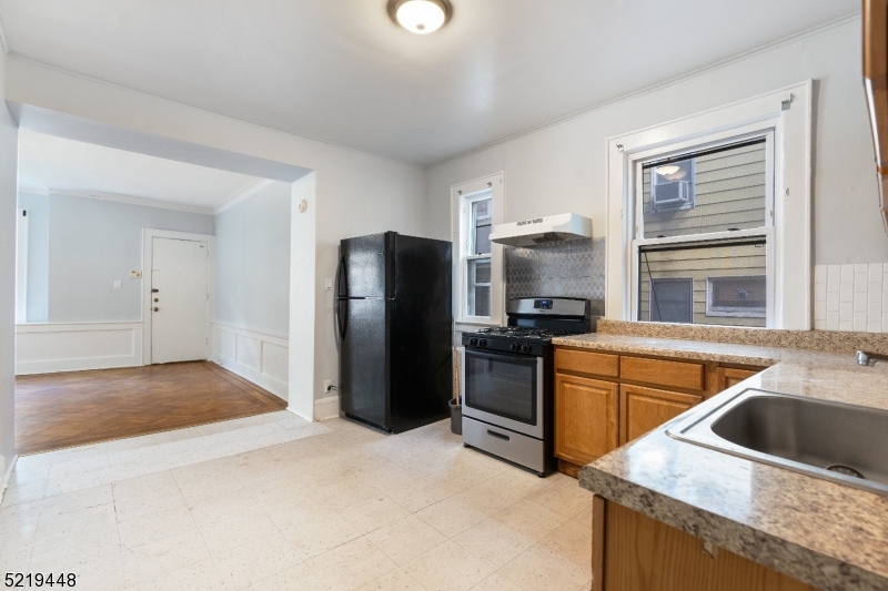 148 Lyons Avenue, Unit 1 Newark, NJ 07112 - Photo 7 of 9 a kitchen with stainless steel appliances granite countertop a refrigerator and a sink