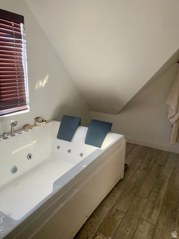 12645 East Cedar Ridge Drive Fairview, UT 84629 - Photo 16 of 25 Bathroom featuring vaulted ceiling, hardwood / wood-style flooring, and a whirlpool tub