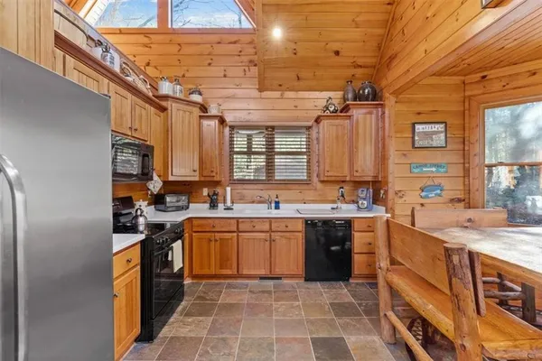a kitchen with stainless steel appliances granite countertop a refrigerator a stove and a sink