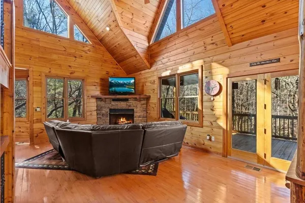 a view of a patio with couches fire pit and a barbeque grill with couches and wooden floor