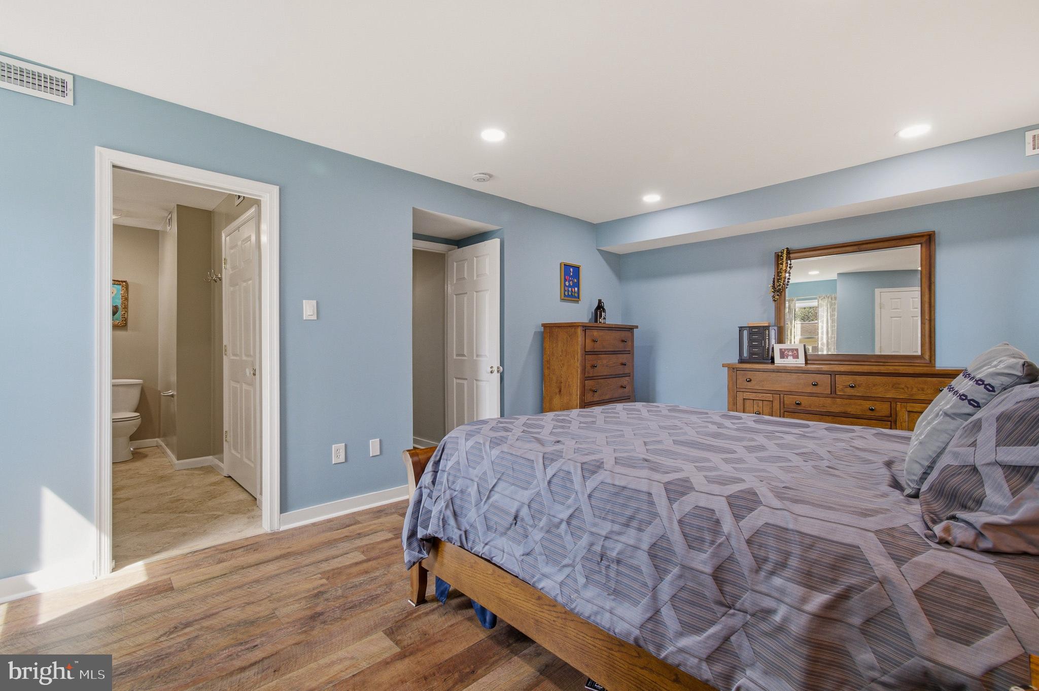 1410 Knights Bridge Turn Crofton, MD 21114 - Photo 34 of 75 a bedroom with a large bed a lamp and wooden floor