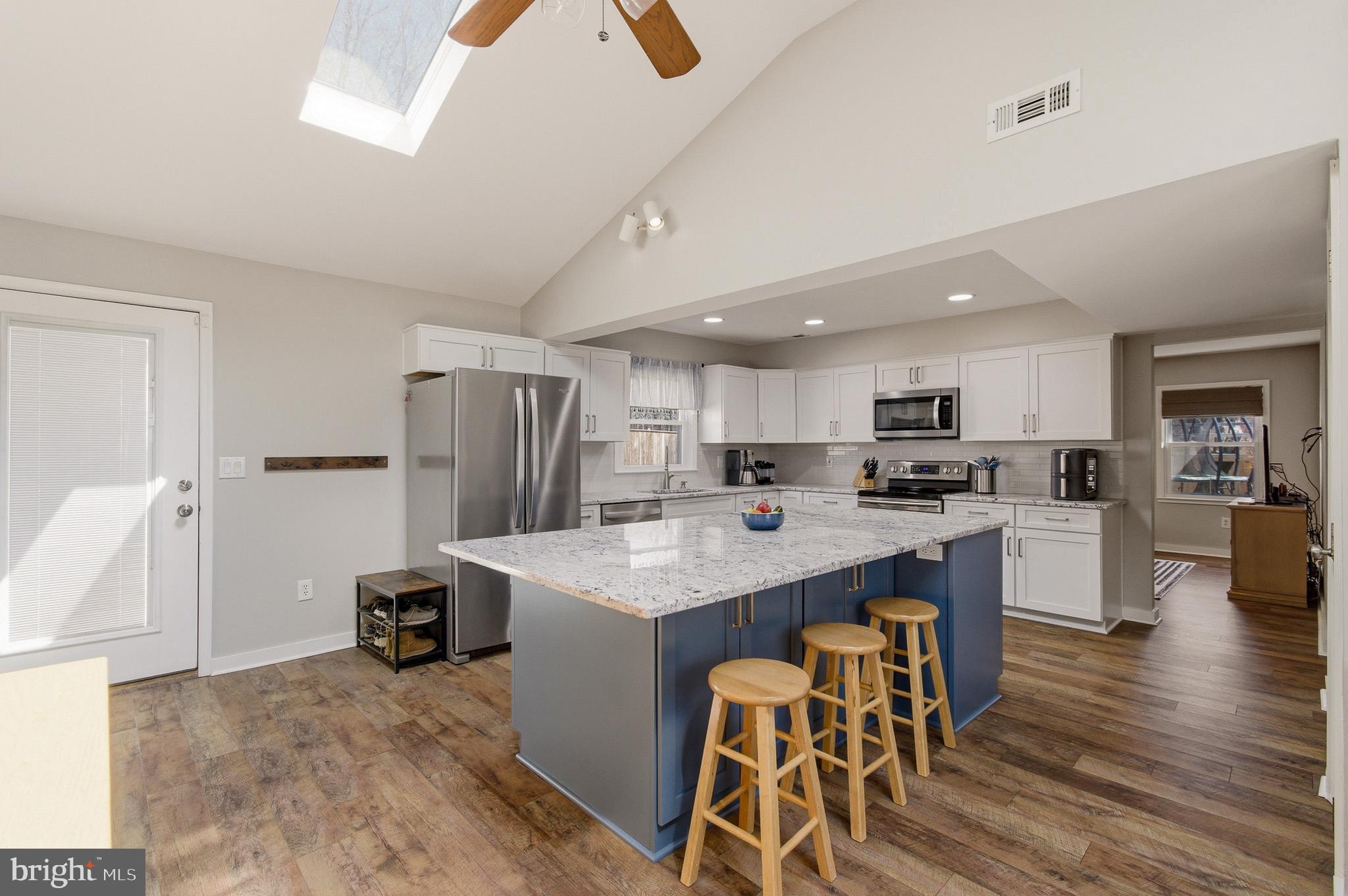 1410 Knights Bridge Turn Crofton, MD 21114 - Photo 9 of 75 a kitchen with stainless steel appliances kitchen island granite countertop a table chairs refrigerator and microwave