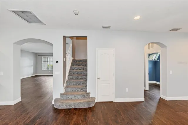 a view of a hallway with a white door and stairs
