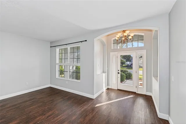 an empty room with wooden floor and a window