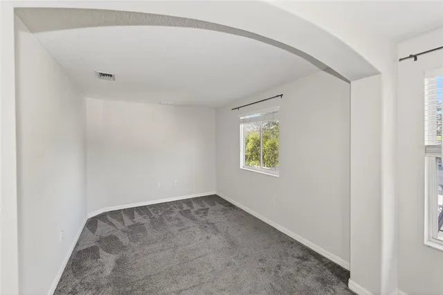 an empty room with closet and a ceiling fan