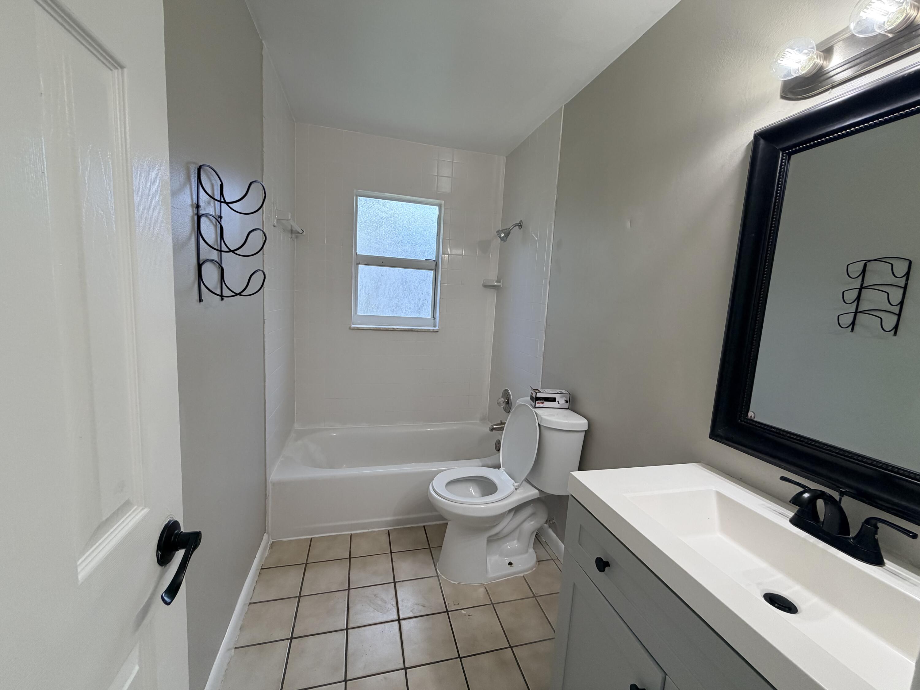 3594 Almar Road, Unit 3 Lake Worth, FL 33461 - Photo 9 of 15 a bathroom with a sink a toilet and shower