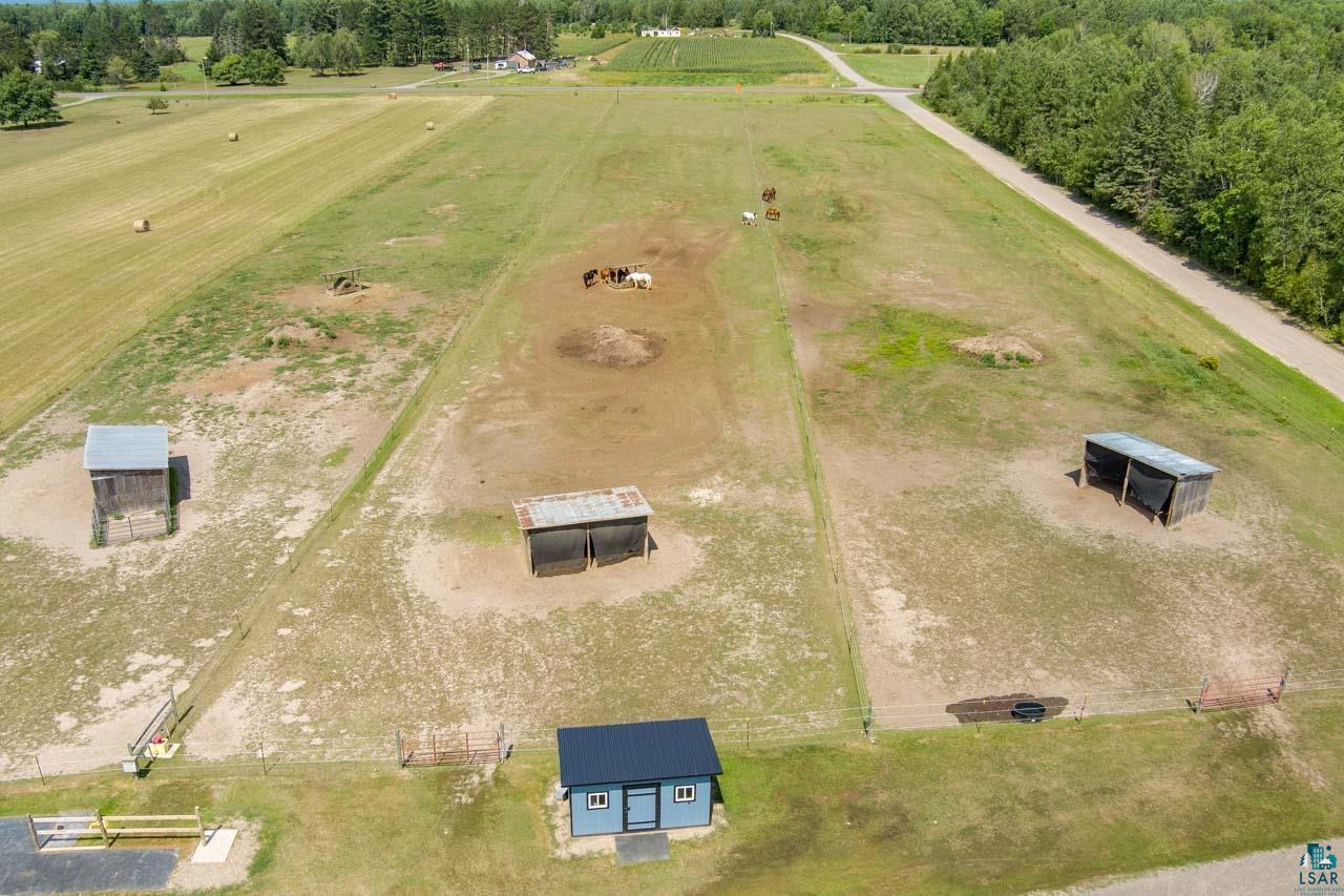 3201 Wilderness Road Makinen, MN 55763 - Photo 39 of 44 Expansive rural property featuring fenced pastures, multiple outbuildings, and a gravel road access