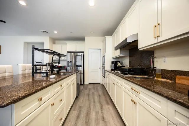 a kitchen with stainless steel appliances granite countertop a sink stove and refrigerator