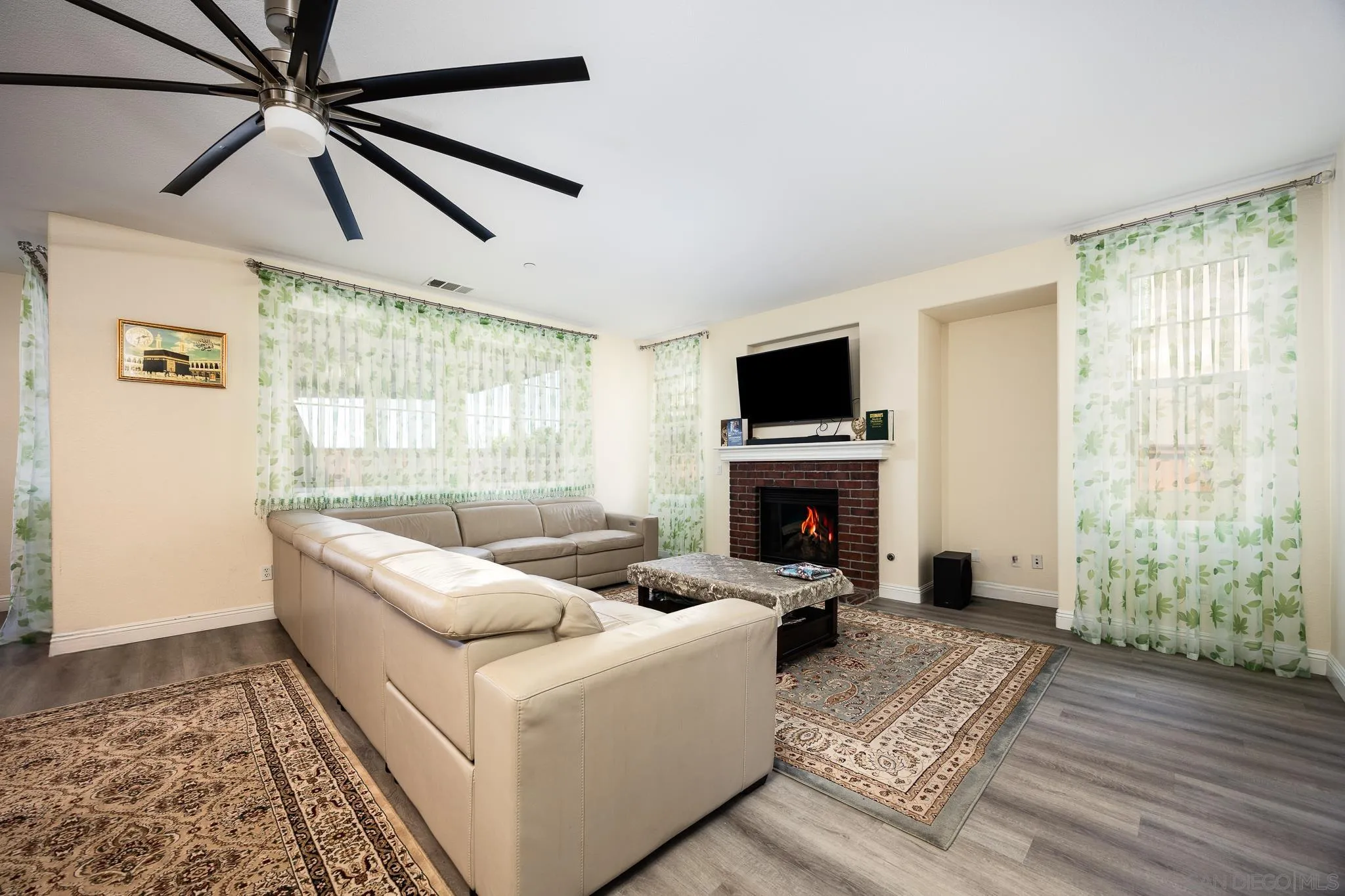 5120 Sevilla Street Santee, CA 92071 - Photo 15 of 44 a living room with furniture a fireplace and a flat screen tv